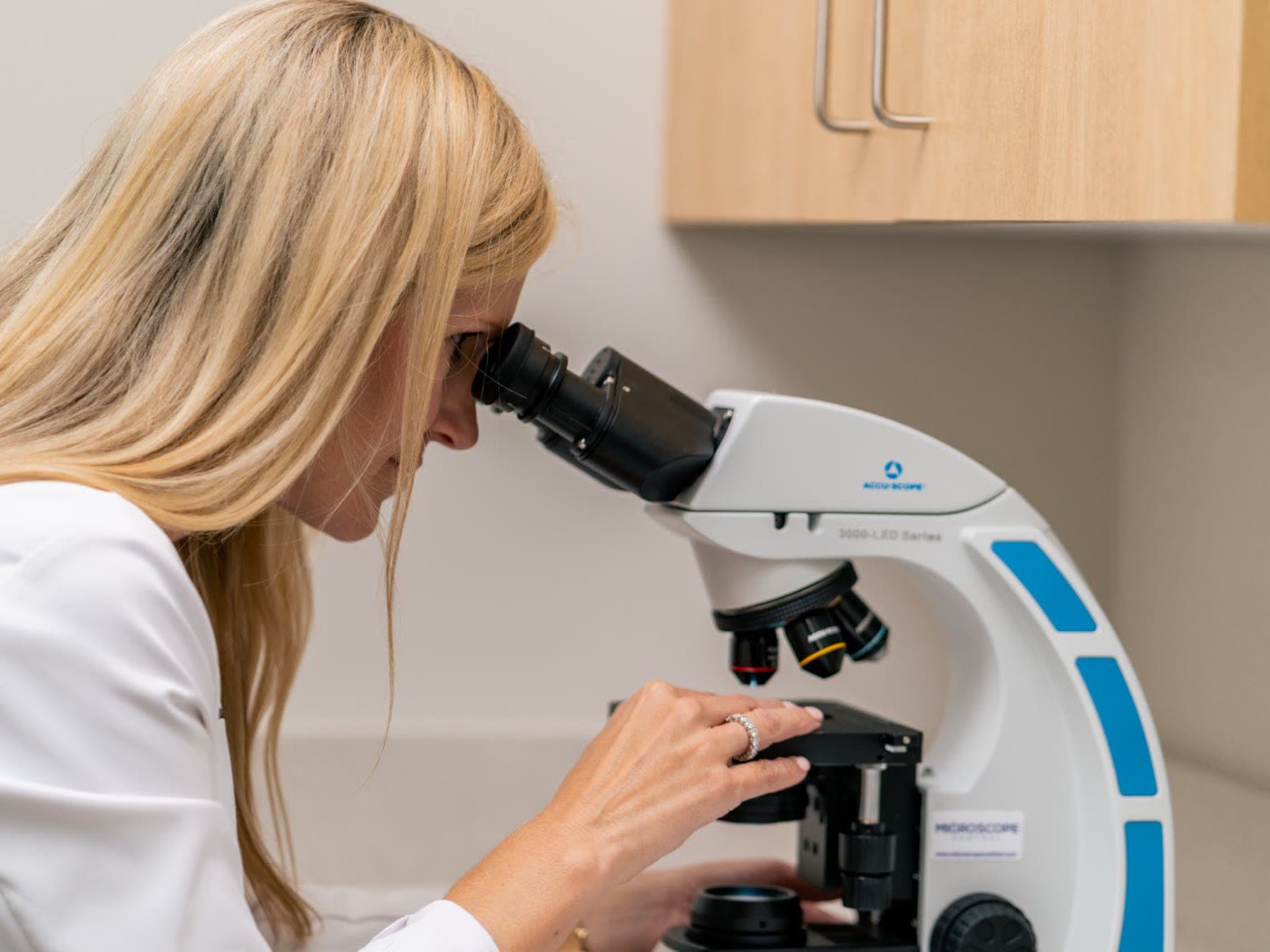 Dr. Sarah Wilson reading Mohs slides under the microscope at Newnan Dermatology