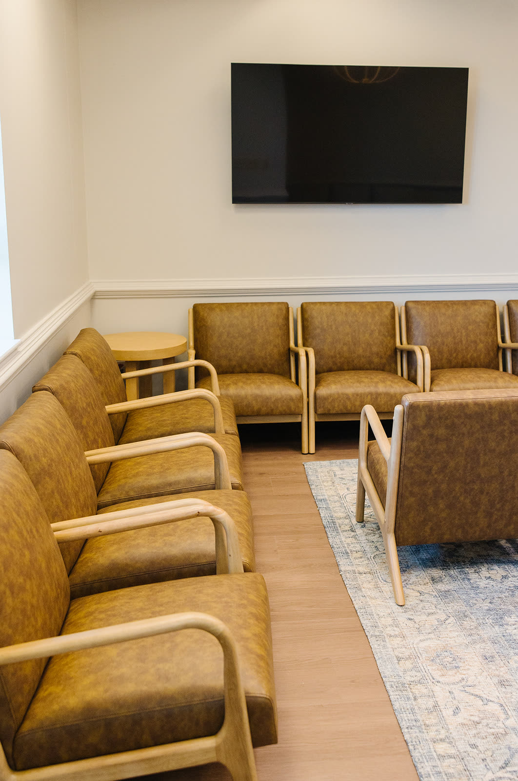 The waiting room at Newnan Dermatology with leather armchairs and natural light